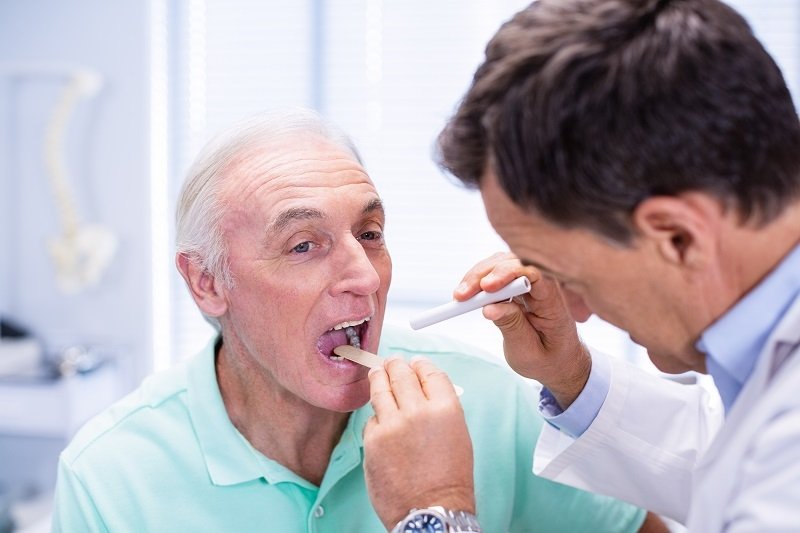 doctor-examining-senior-patients-mouth-2021-08-28-16-45-01-utc